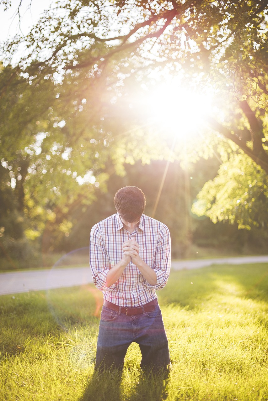 Man kneeling in prayer with heavy burden lifted