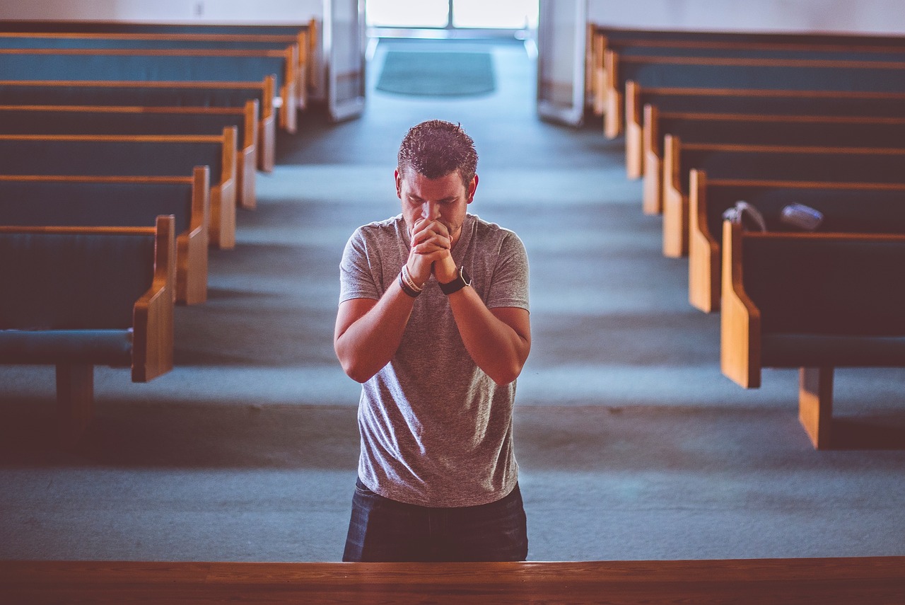 Person kneeling on altar representing living sacrifice