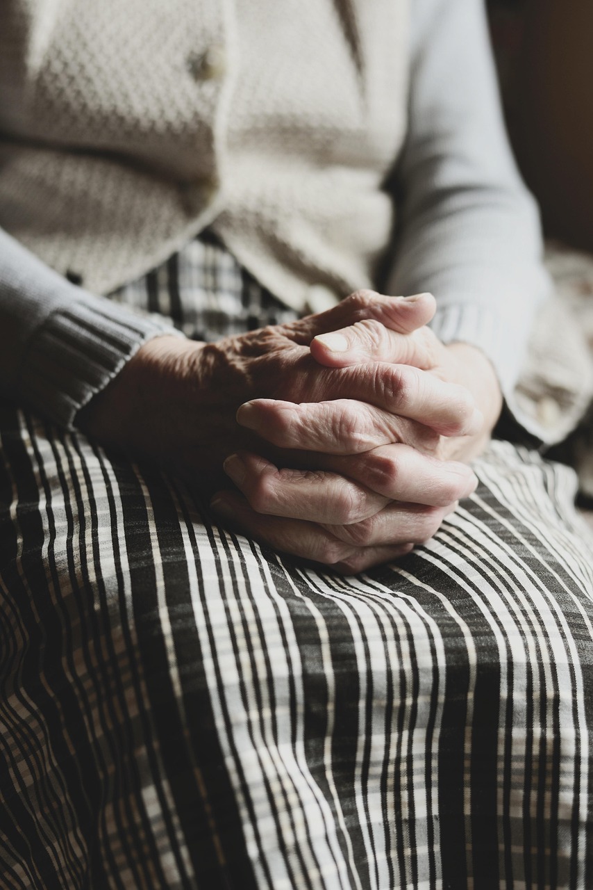 I wonder as I wander. elderly hands clasped in prayer with soft sunset background, symbolizing last day reflections