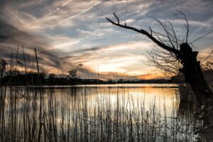 Sunrise over peaceful lake symbolizing Christian transformation and taking time to be holy