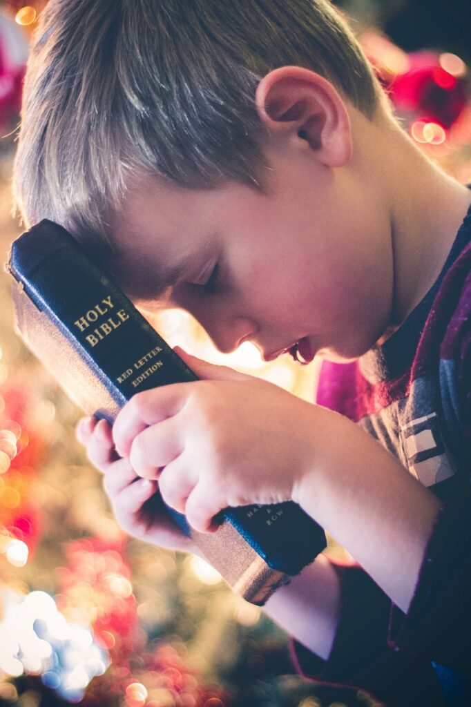 Child with Bible with glowing light showing that God speaks to you