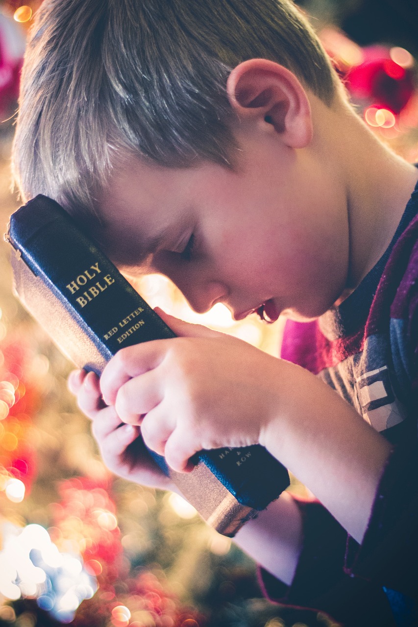 Child with Bible with glowing light showing that God speaks to you