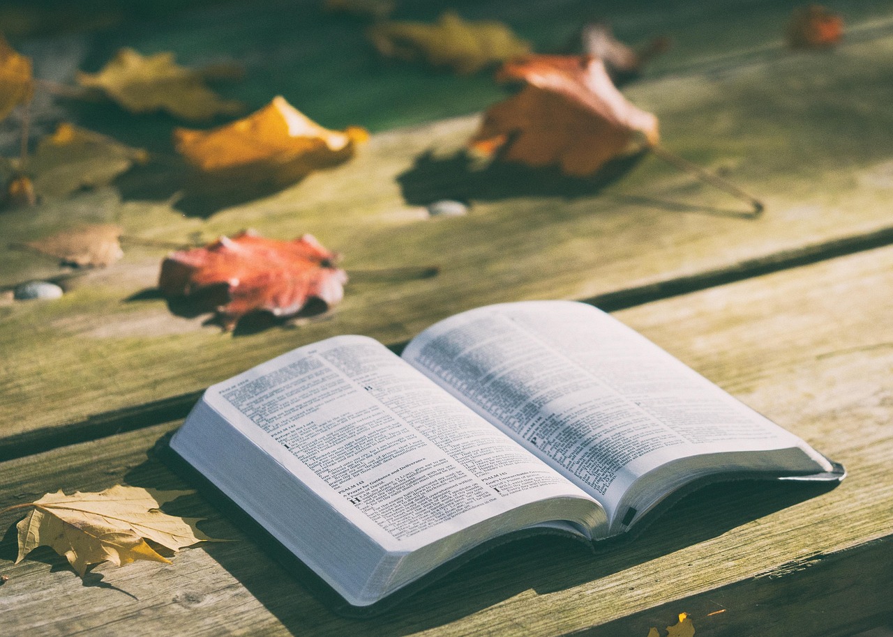 Open Bible beside a Thanksgiving table with autumn colors
