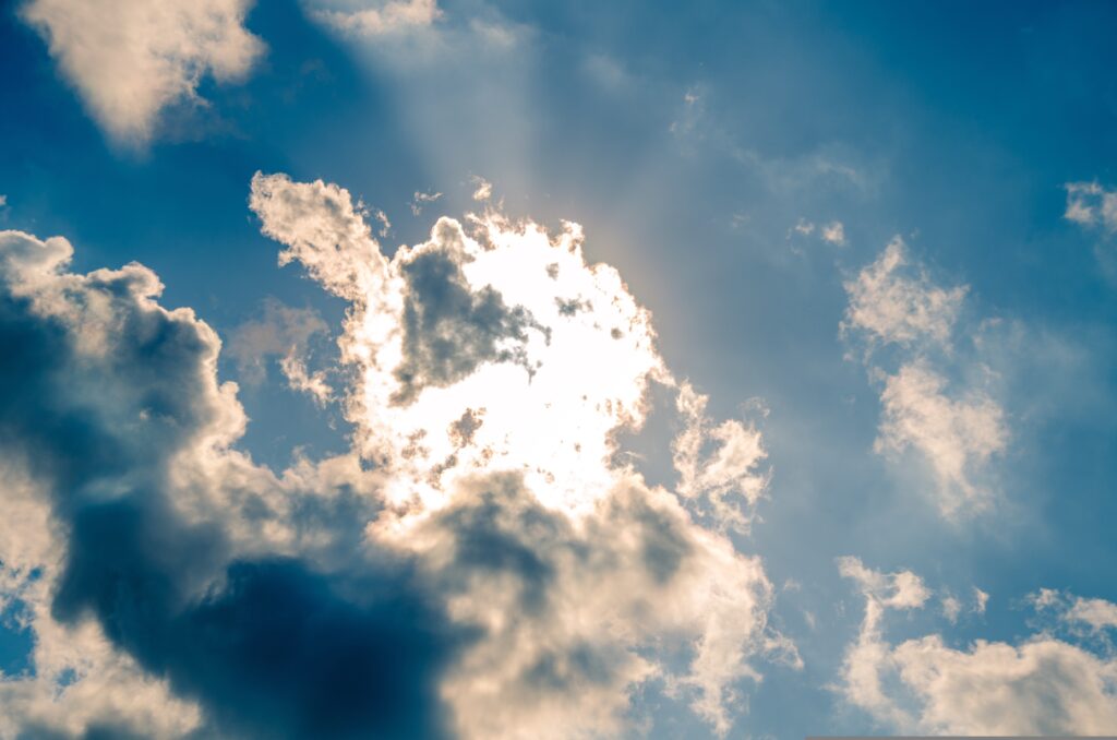 Sunlight shining through clouds symbolizing the breath and presence of God’s Spirit