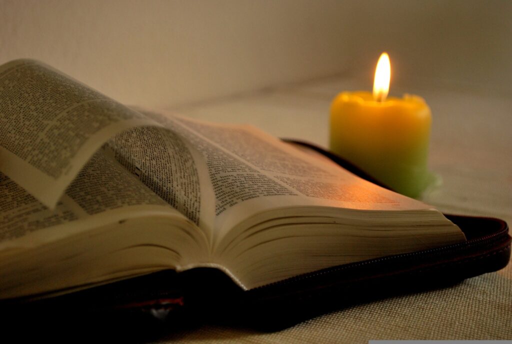"A serene open Bible with soft morning light streaming through a window, surrounded by gentle rays of candle light symbolizing new mercies,