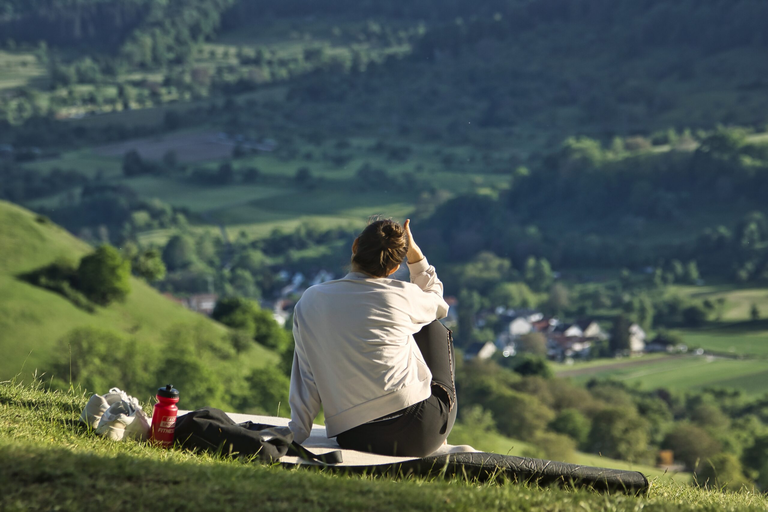 Christian overlooking a peaceful countryside scene symbolizing contentment in Christ.
