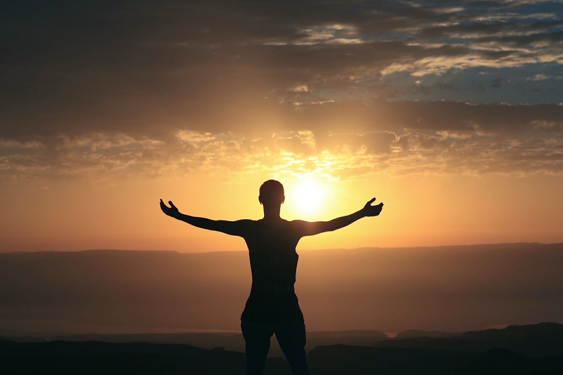 Hands lifted in complete surrender as the morning sunlight shines through, symbolizing a heart fully open to God.