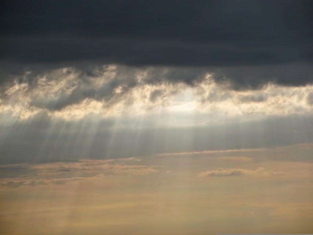 Sunlight breaking through clouds symbolizing adoption as children of God