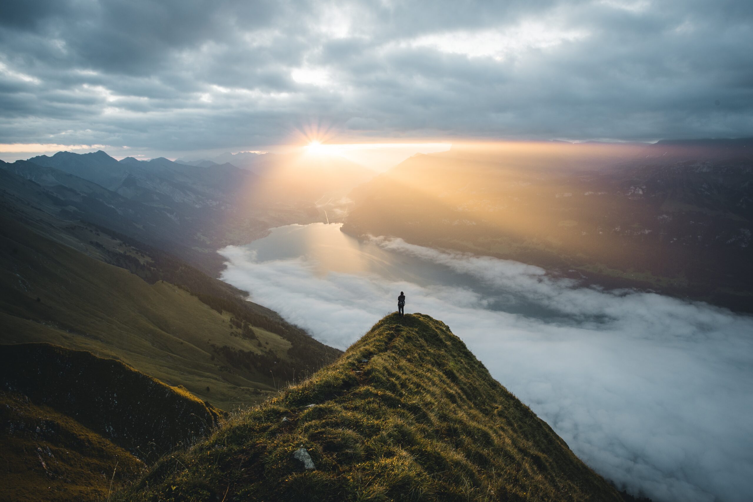 Morning sunlight breaking over a quiet mountain landscape, symbolizing God's still small voice and His peaceful presence.