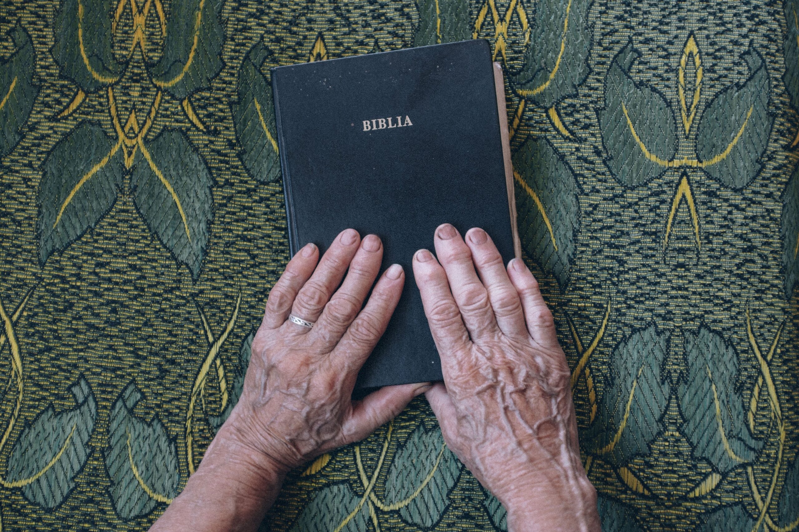 Bible with well-worn hands , symbolizing faith put into action through obedient Christian living.
