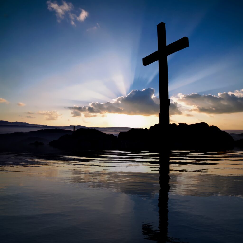 Sunrise over a rugged wooden cross, illustrating God's everlasting love revealed through Jesus Christ.