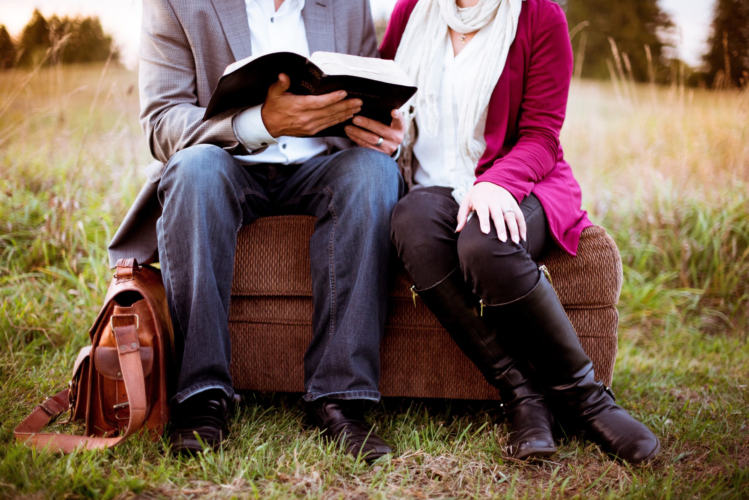 Two friends sitting together with an open Bible, sharing honest conversation as accountability partners in faith