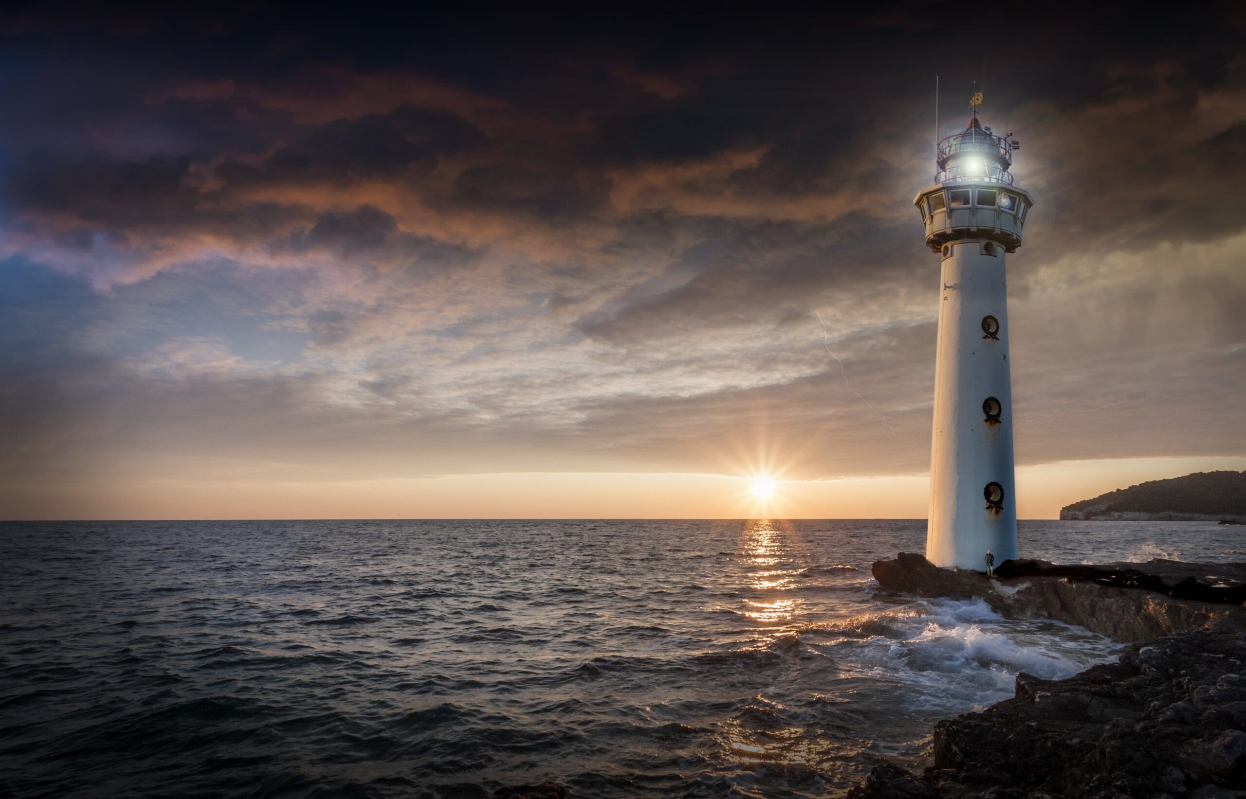 A lighthouse standing firm on a rocky shoreline against crashing waves, illustrating how to stand firm in faith